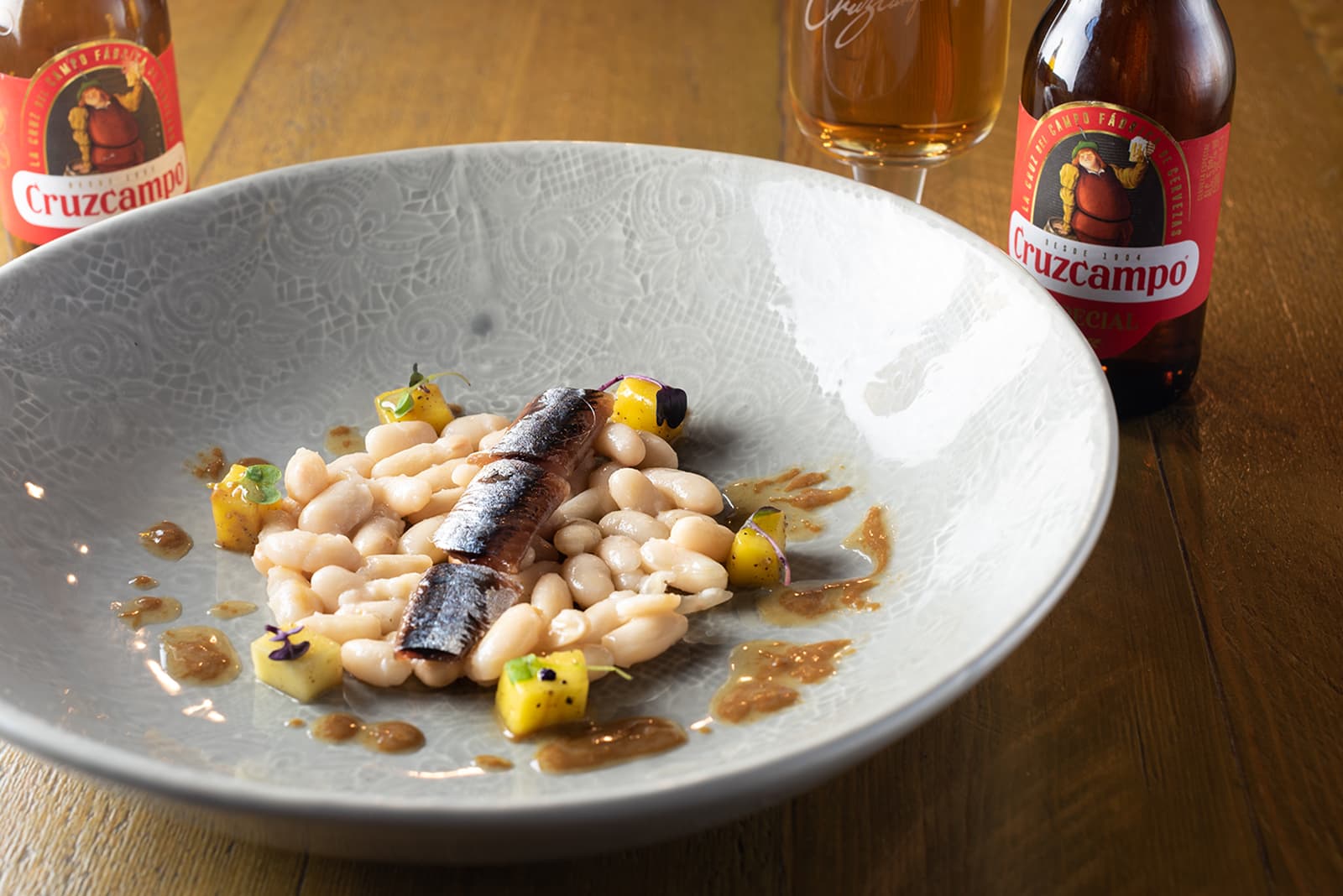 Ensalada tibia de alubias, sardina ahumada y mango